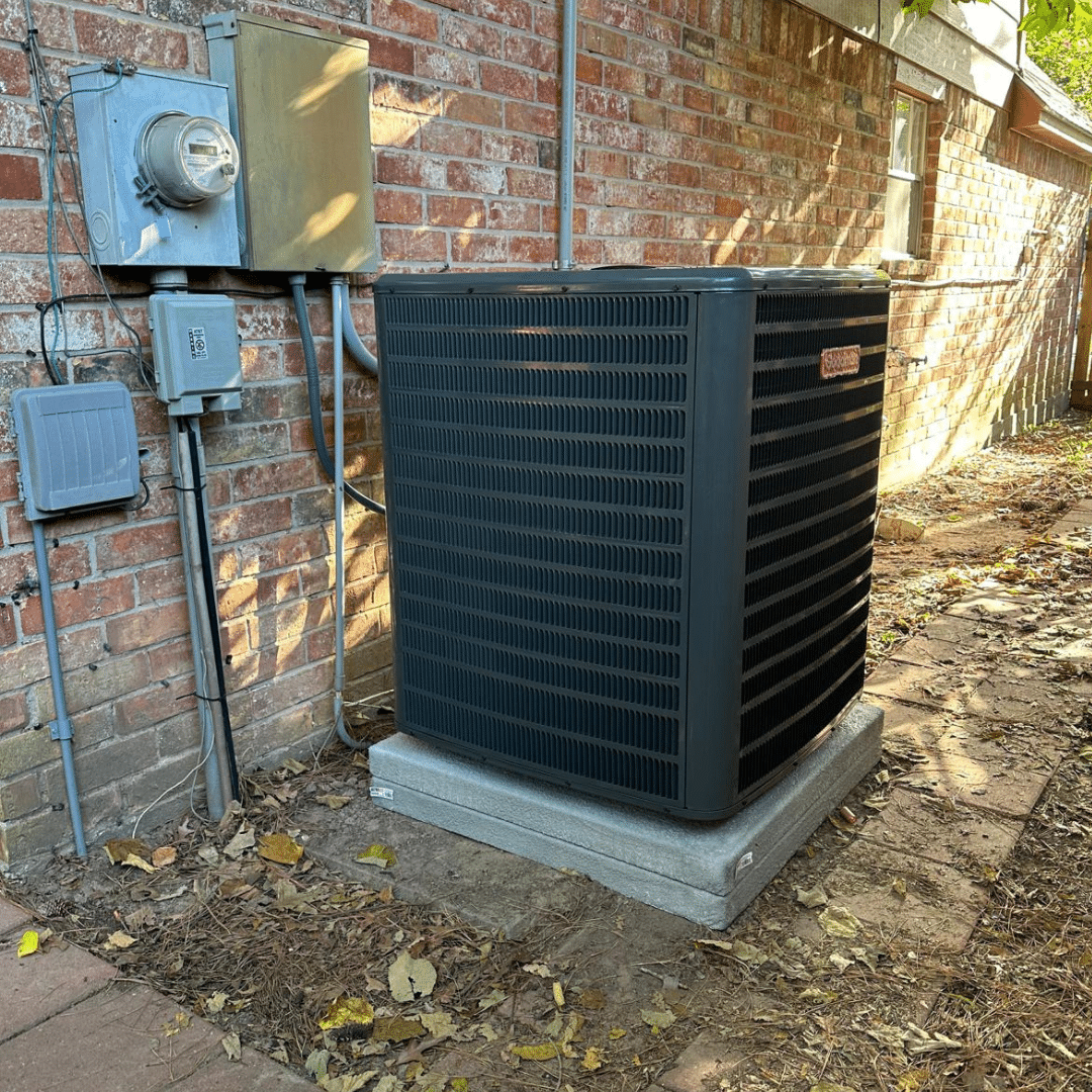 Air conditioning unit beside brick wall
