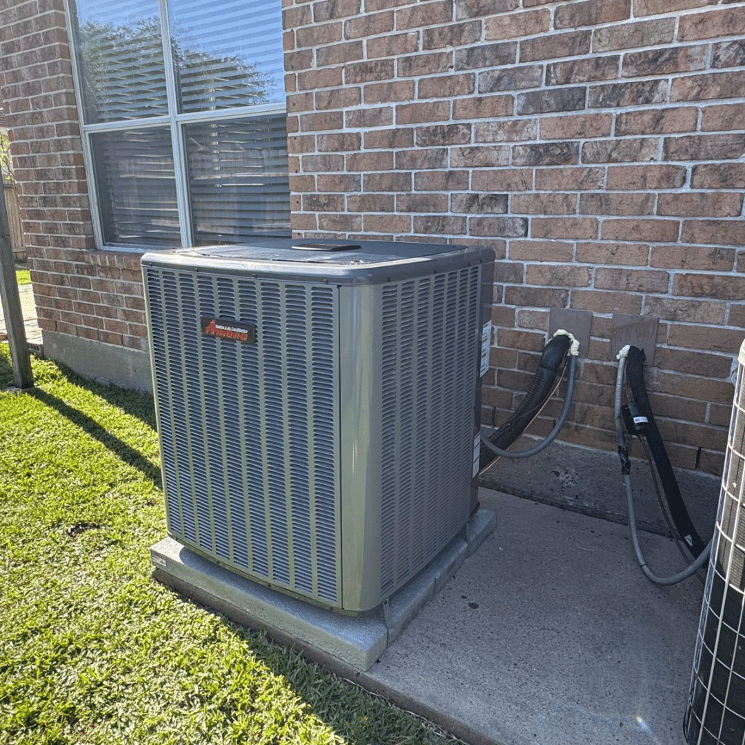 Air conditioning unit beside brick wall