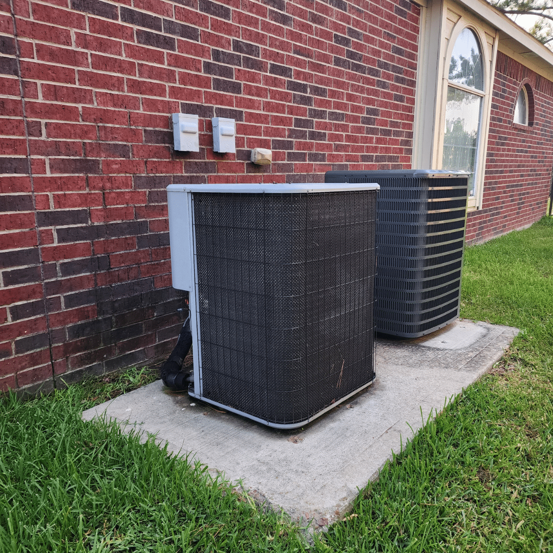 Two air conditioning units outside a house.