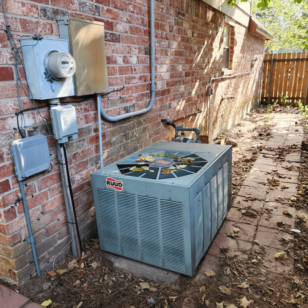 Air conditioning unit beside brick wall