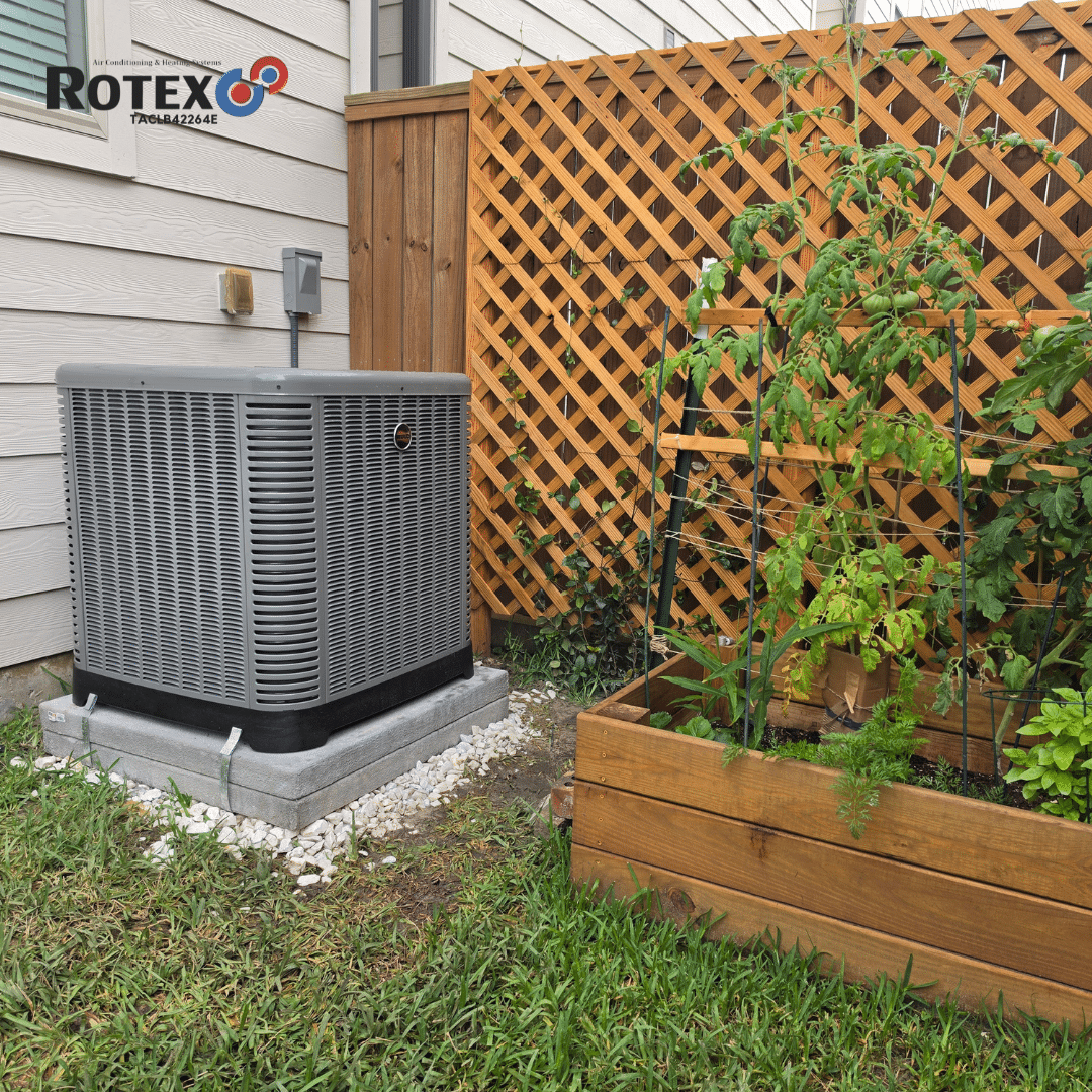 Air conditioning unit beside garden bed